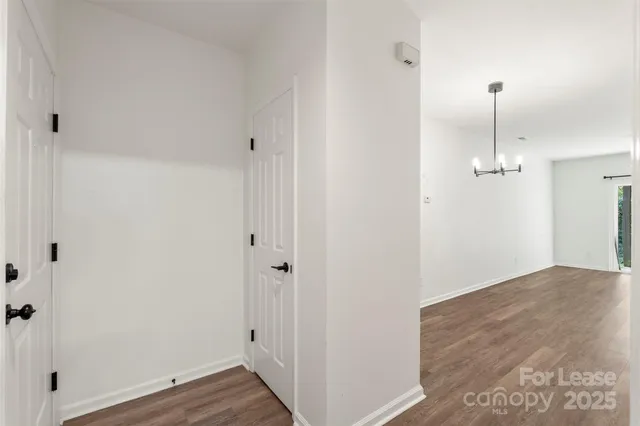 a view of a hallway with wooden floor and closet area
