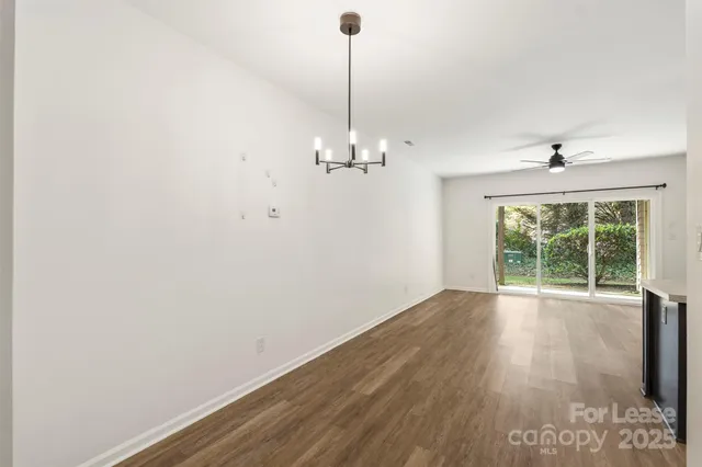 a view of a room with wooden floor fan and window