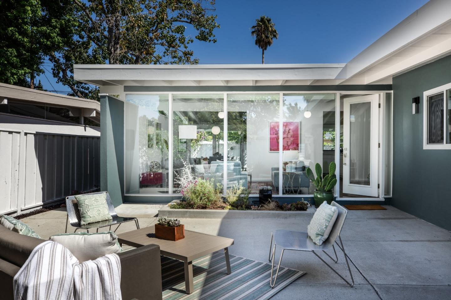 a view of a patio with dining table and chairs with wooden floor and fence