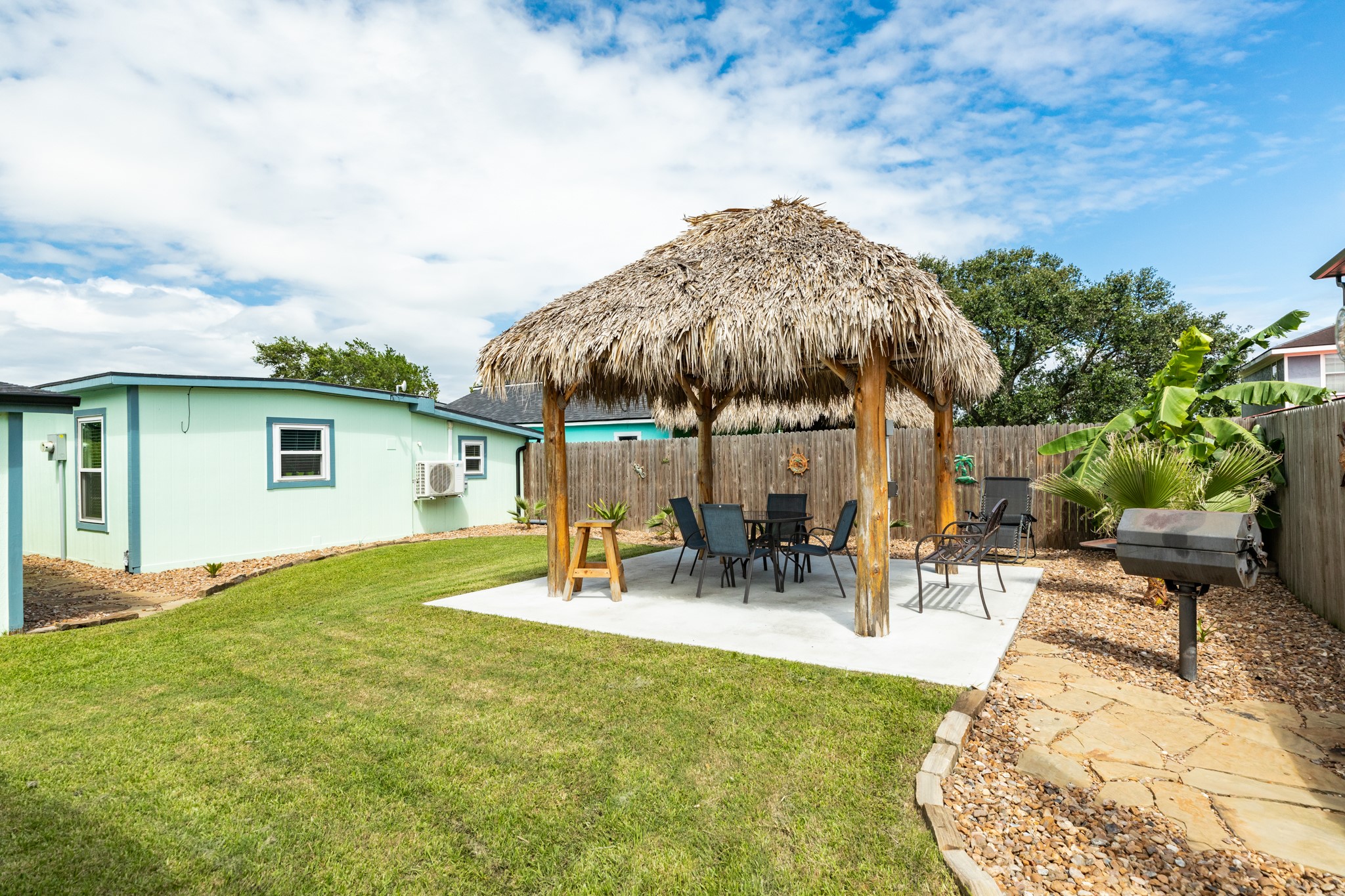 4402 Zelsky Road Freeport, TX 77541 - Photo 26 of 37 a view of a backyard with table and chairs potted plants and a palm tree