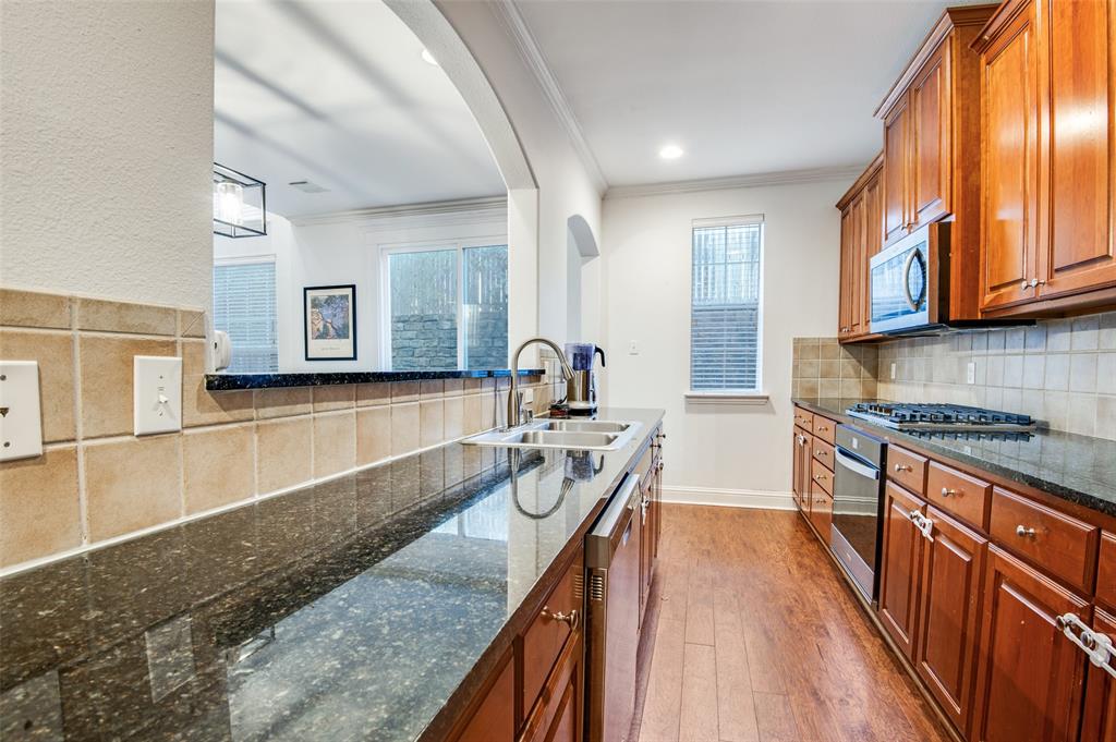 2505 Corbeau Drive Irving, TX 75038 - Photo 12 of 25 Gleaming countertops, neutral backsplash and wooden floors create a chef's dream kitchen.