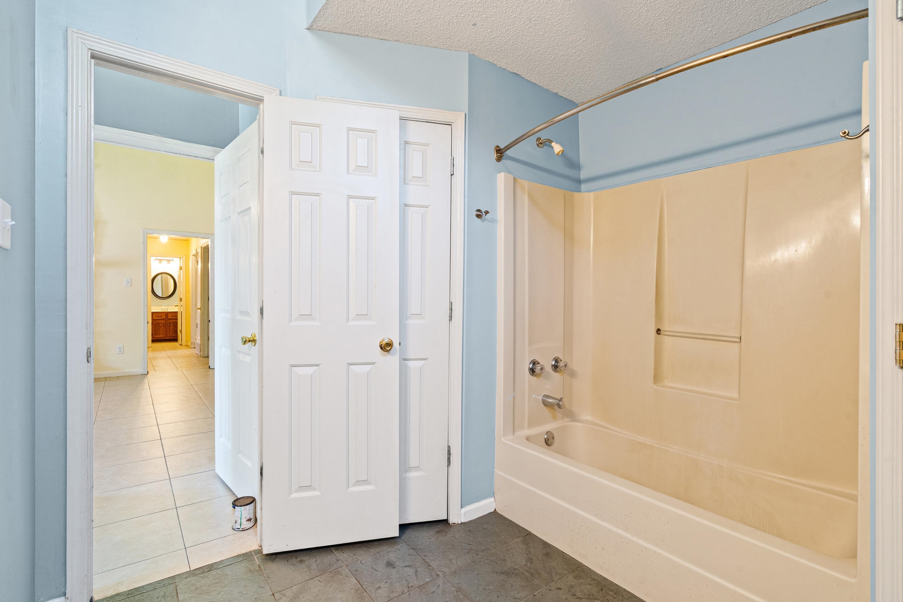 7130 Bryan Station Road Cordova, TN 38018 - Photo 14 of 26 Bathroom featuring a white tub-shower combination with a curved shower rod and blue painted walls