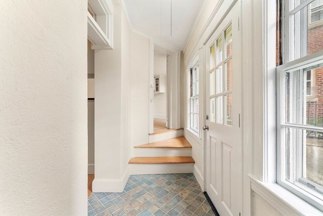 a view of a hallway with wooden floor and windows