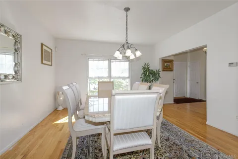a dining room with furniture a chandelier and wooden floor