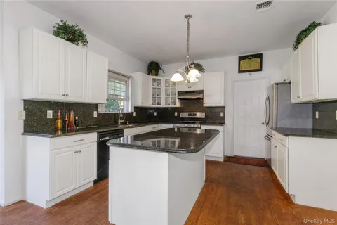a kitchen with granite countertop a sink stainless steel appliances and cabinets