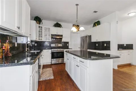 a kitchen with stainless steel appliances granite countertop a sink a stove and a refrigerator