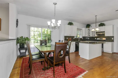 a view of a dining room and livingroom with furniture wooden floor a chandelier