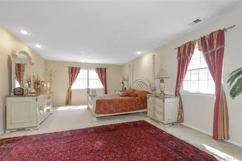 a spacious bedroom with a bed and a large mirror