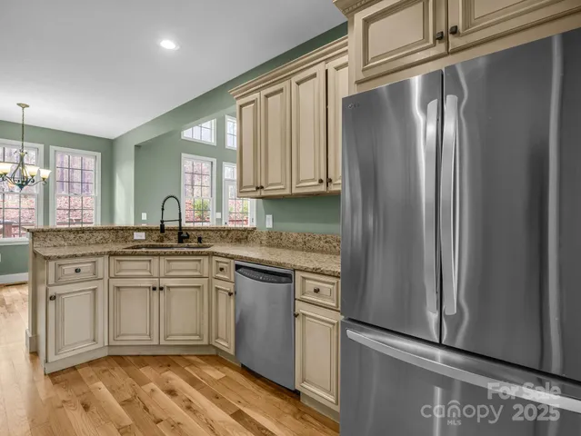 a kitchen with stainless steel appliances granite countertop a refrigerator and a sink