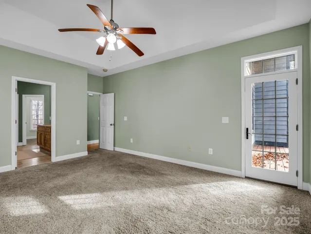 an empty room with windows and ceiling fan