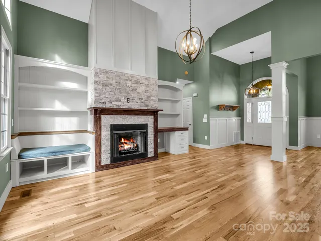 a view of a livingroom with wooden floor a fireplace and window