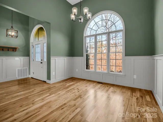a view of front door with wooden floor and a window