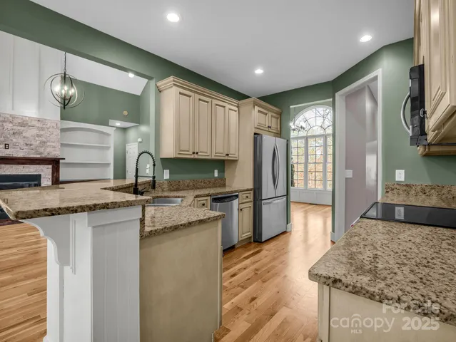 a kitchen with stainless steel appliances granite countertop a sink stove and refrigerator