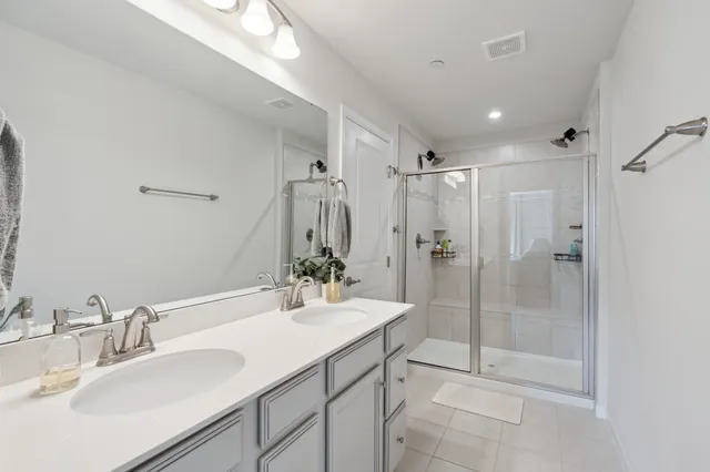 a bathroom with a shower sink vanity mirror and toilet