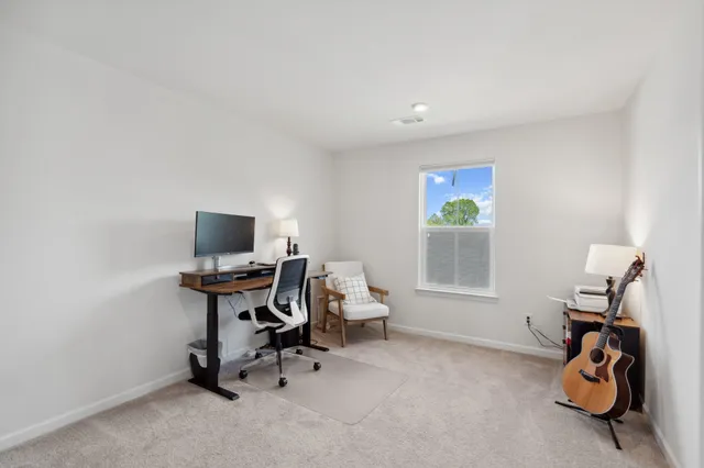 a view of a workspace with furniture and a window