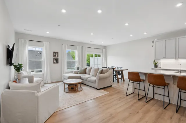 a living room with furniture a wooden floor and a large window