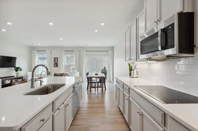 a kitchen with stainless steel appliances a sink microwave and cabinets