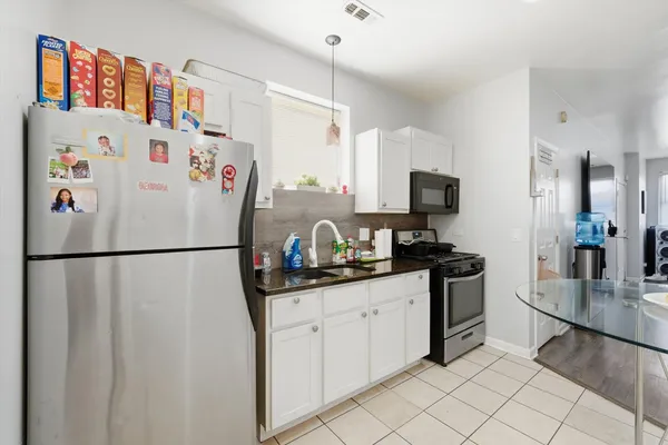 a kitchen with stainless steel appliances granite countertop a stove a refrigerator and a microwave