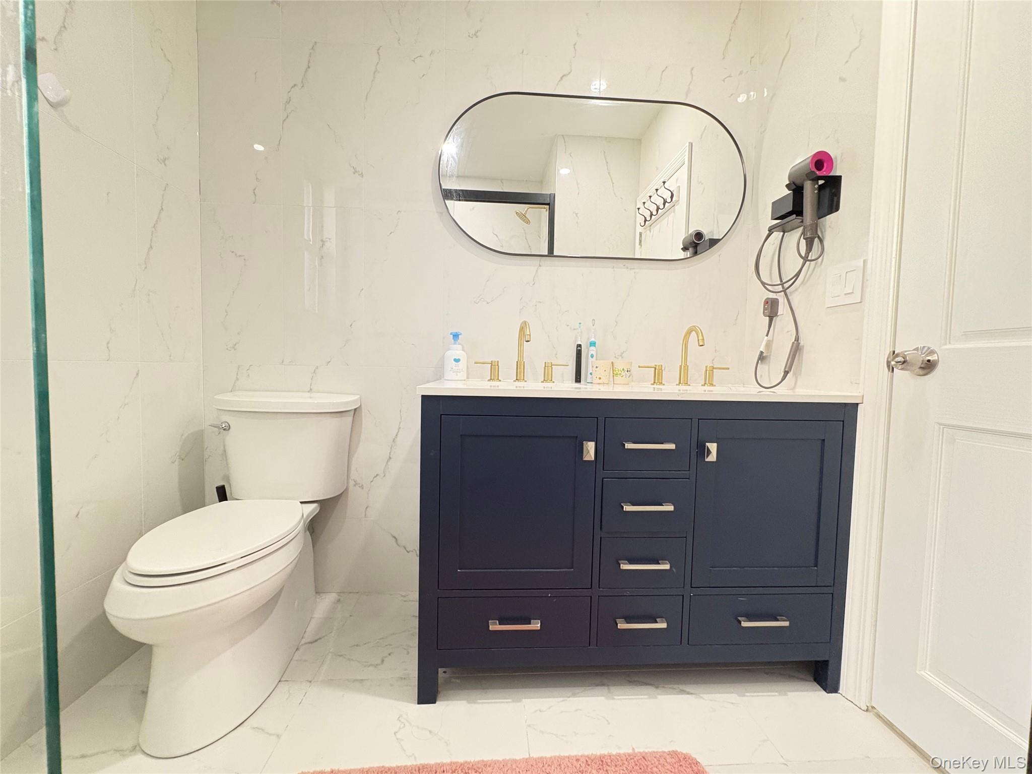 41-75 Morgan Street Queens, NY 11363 - Photo 29 of 50 a bathroom with a toilet sink vanity and mirror