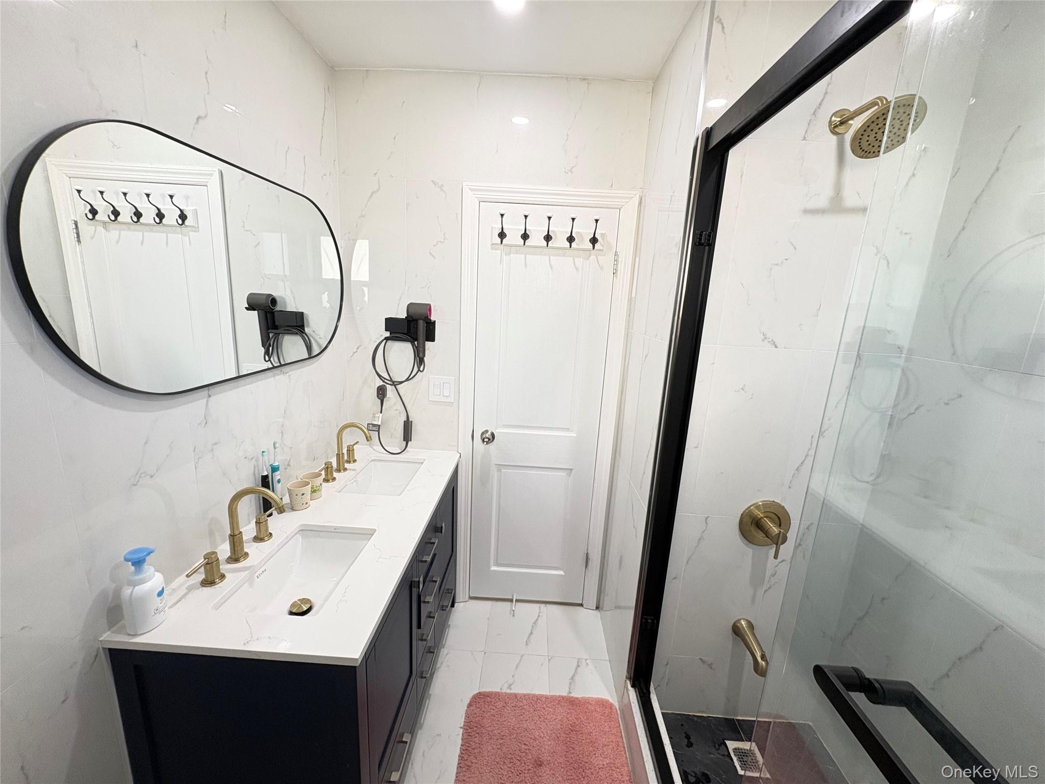 41-75 Morgan Street Queens, NY 11363 - Photo 31 of 50 a bathroom with a sink a mirror and a shower