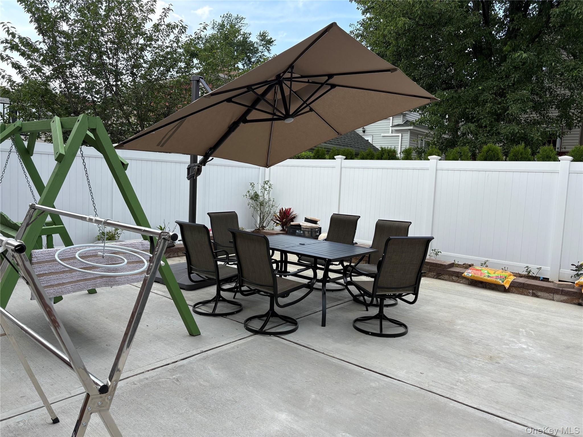 41-75 Morgan Street Queens, NY 11363 - Photo 47 of 50 a view of backyard with table and chairs under an umbrella