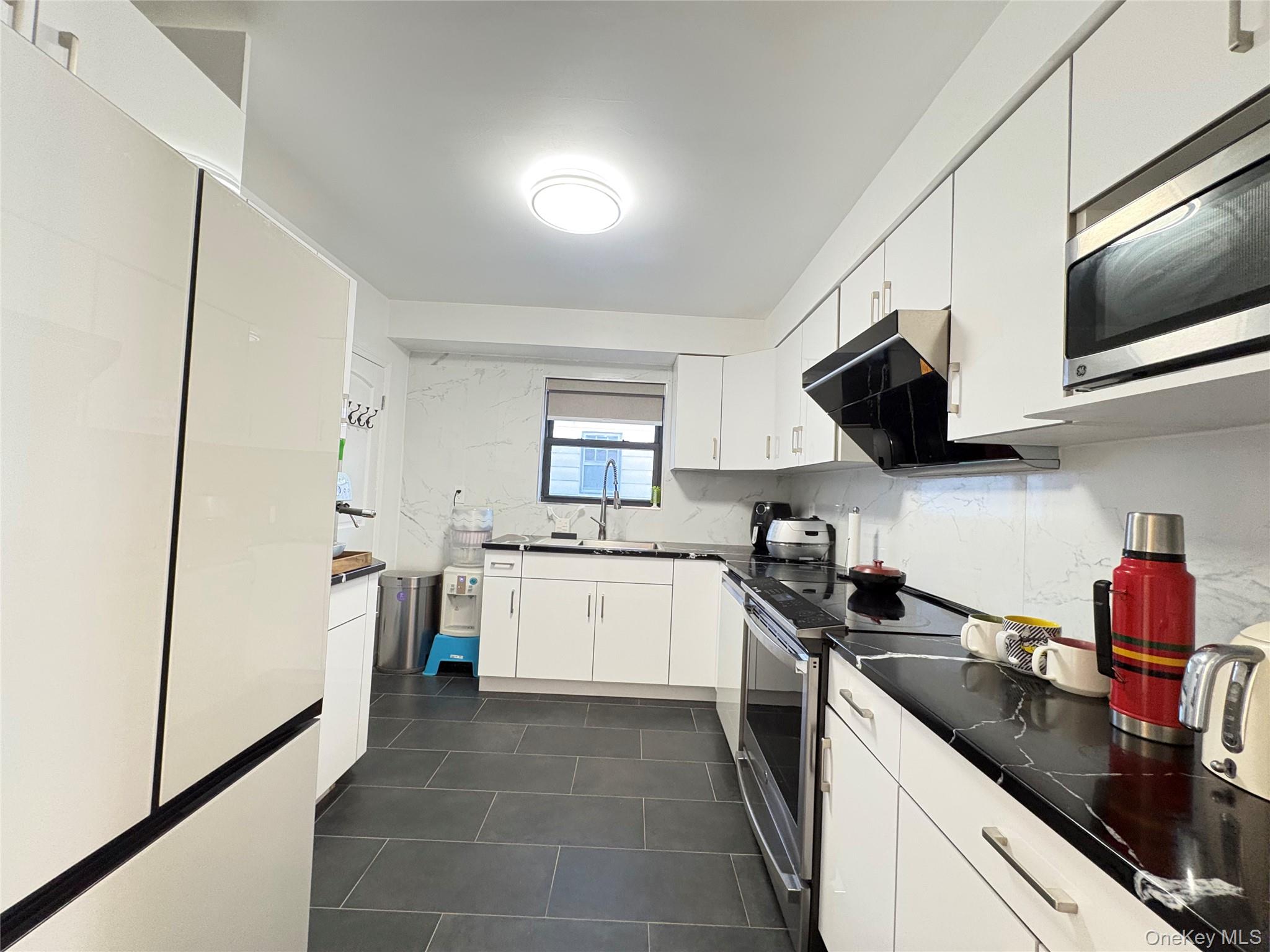41-75 Morgan Street Queens, NY 11363 - Photo 10 of 50 a kitchen with stainless steel appliances granite countertop a sink stove microwave and refrigerator
