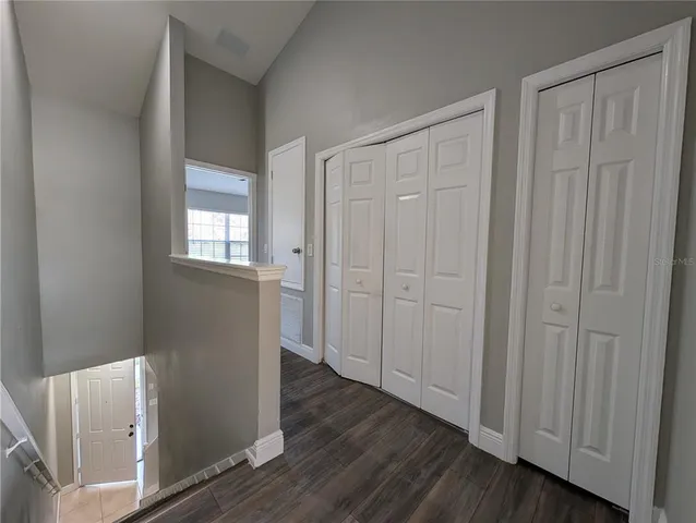 a view of a closet area with wooden floor