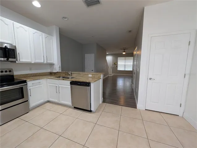 a kitchen with stainless steel appliances granite countertop a refrigerator and a stove top oven