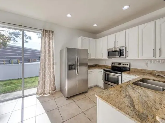a kitchen with stainless steel appliances granite countertop a refrigerator and a stove top oven