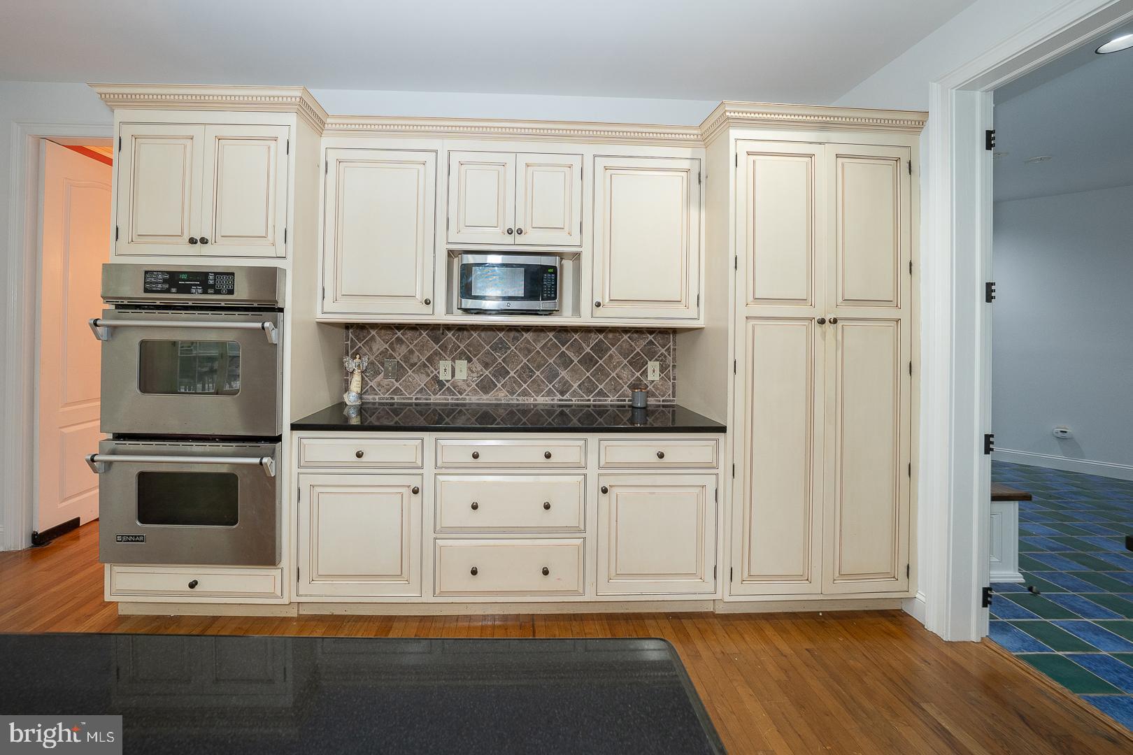 899 Black Rock Road Gladwyne, PA 19035 - Photo 7 of 59 a kitchen with stainless steel appliances granite countertop a stove a microwave and a white cabinets