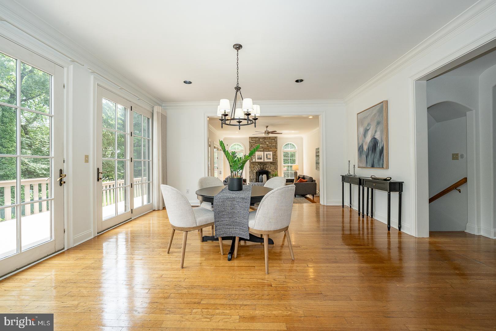 899 Black Rock Road Gladwyne, PA 19035 - Photo 9 of 59 a dining room with wooden floor a chandelier a glass table and chairs