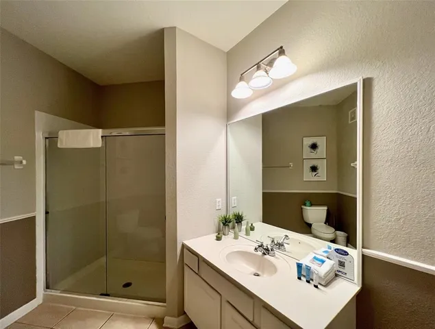 a bathroom with a sink mirror and shower