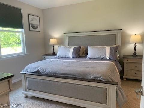 14631 Edgewater Circle Naples, FL 34114 - Photo 11 of 16 a bedroom with a bed and a lamp on dresser