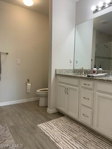 14631 Edgewater Circle Naples, FL 34114 - Photo 14 of 16 a spacious bathroom with a granite countertop sink a toilet and a mirror