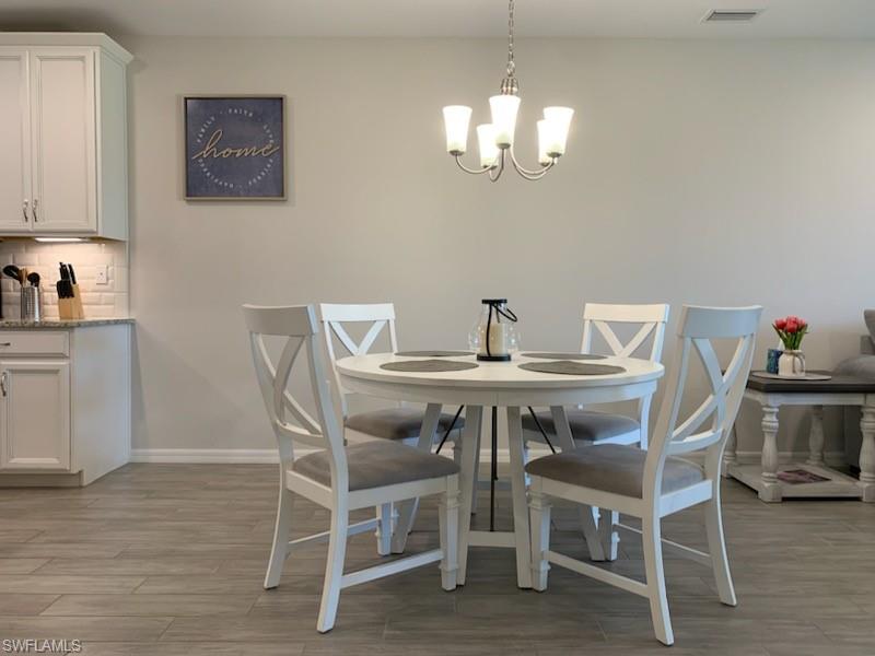 14631 Edgewater Circle Naples, FL 34114 - Photo 6 of 16 a view of a dining room with furniture and wooden floor