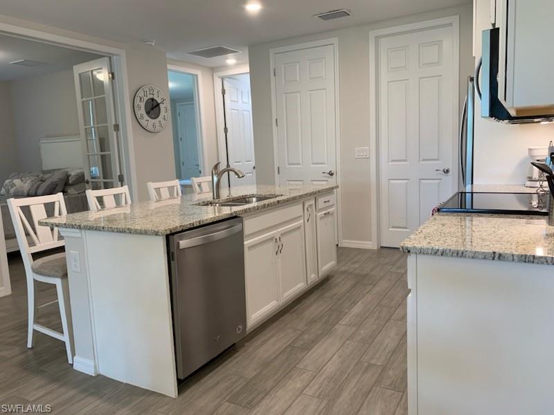 14631 Edgewater Circle Naples, FL 34114 - Photo 7 of 16 a kitchen with a sink stove and cabinets