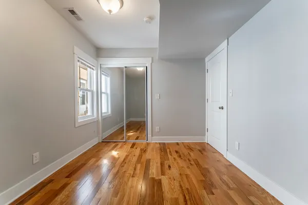 a view of empty room with wooden floor