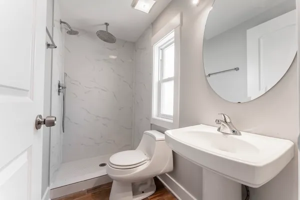 a bathroom with a sink a toilet and shower