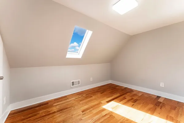 a view of a room with wooden floor and white walls