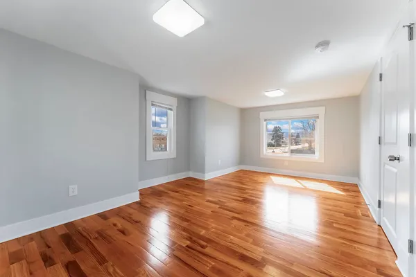 a view of empty room with wooden floor