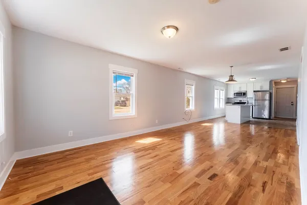 a view of empty room with wooden floor