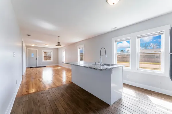 a view of kitchen and hall with wooden floor