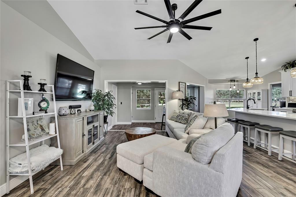 11419 Old Crystal River Road Brooksville, FL 34601 - Photo 5 of 89 a living room with furniture a flat screen tv and a fireplace