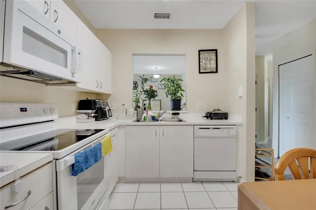 a kitchen with a stove sink and cabinets