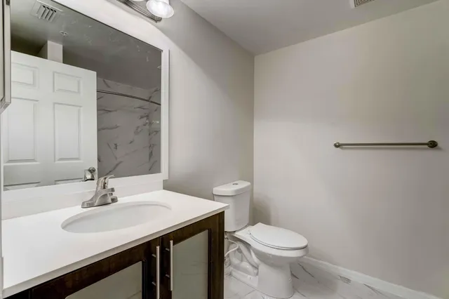 a bathroom with a sink toilet and a mirror