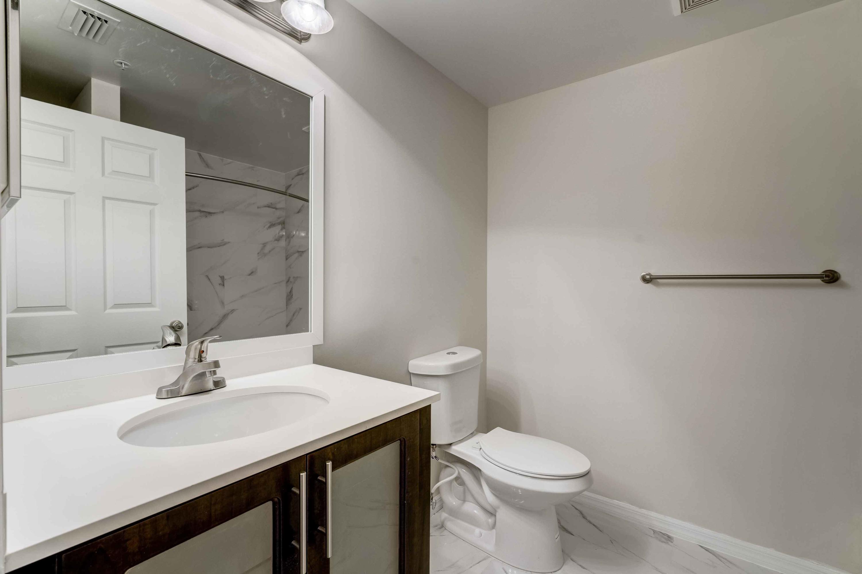 4685 Haverhill Road, Unit B11 West Palm Beach, FL 33417 - Photo 20 of 36 a bathroom with a sink toilet and a mirror