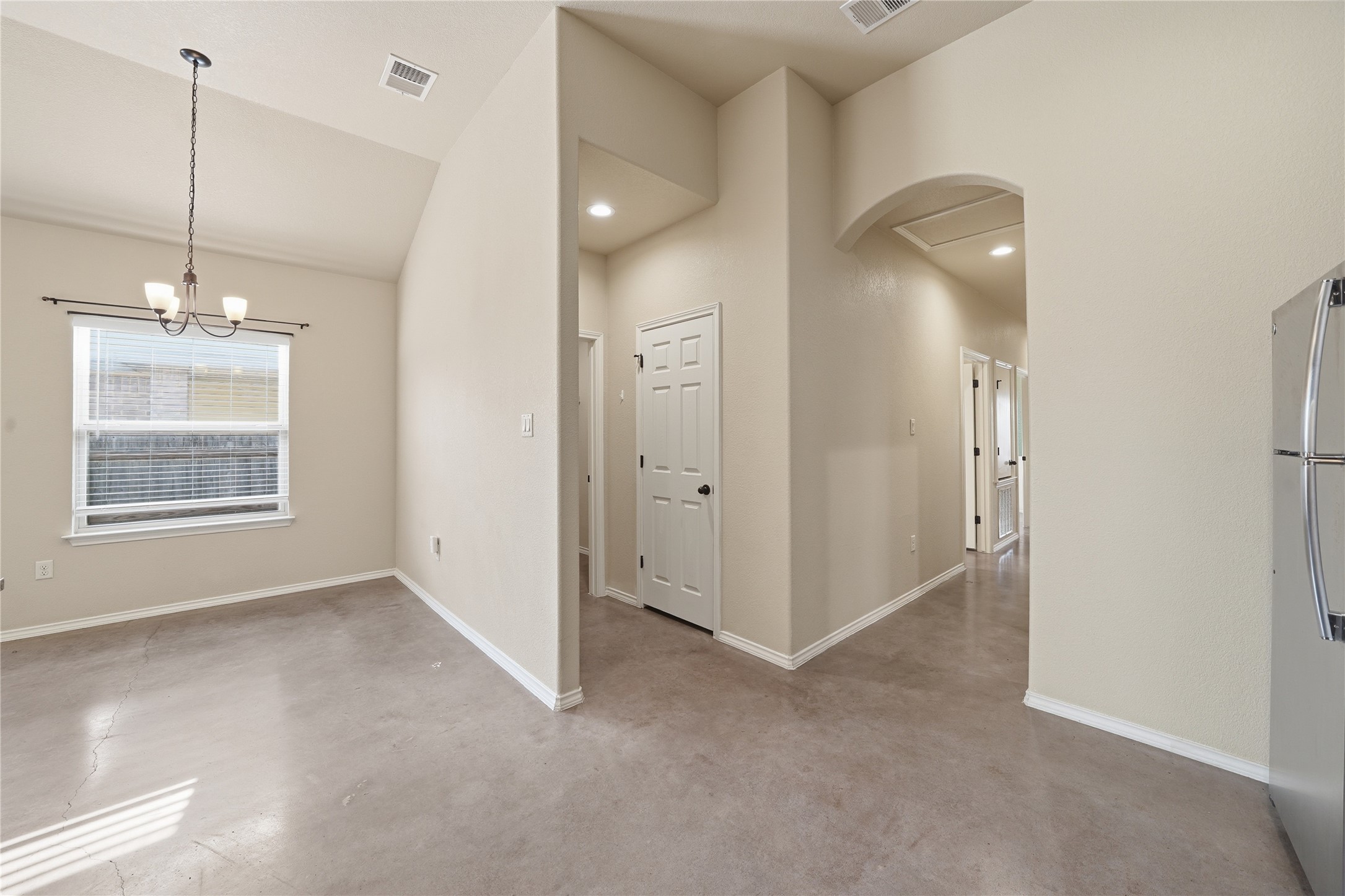 533 Jack Rabbit Lane, Unit A Buda, TX 78610 - Photo 12 of 34 Discover a welcoming dining area featuring vaulted ceilings and polished concrete floors.