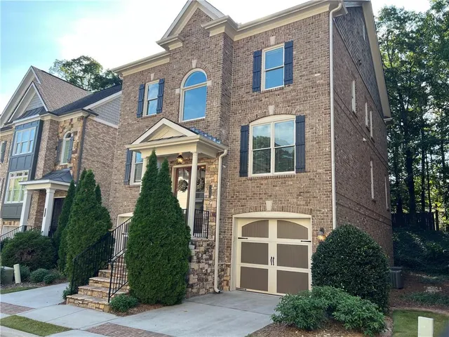 a front view of a house with glass windows and brick walls