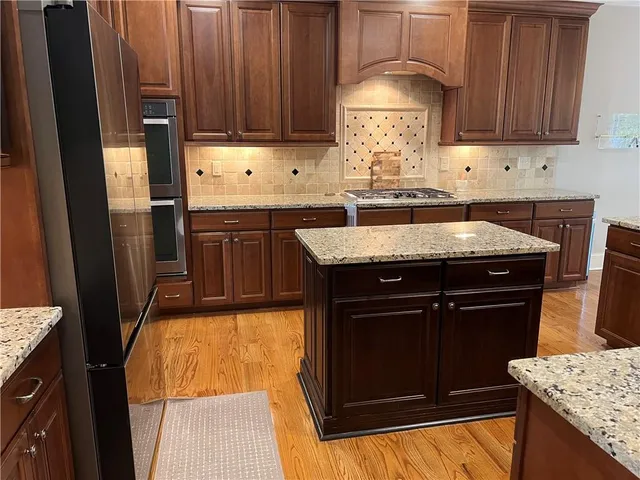 a kitchen with granite countertop a refrigerator and a sink
