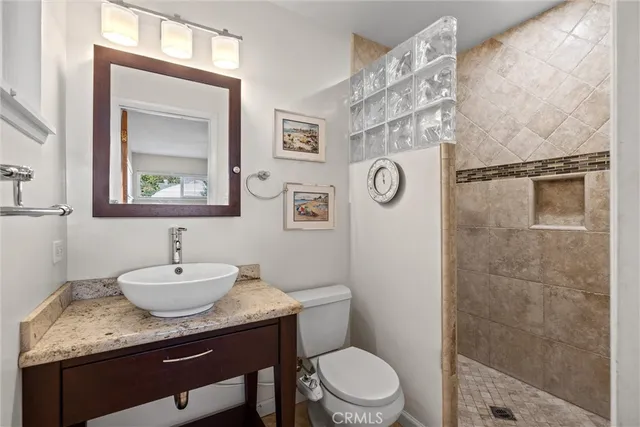 a bathroom with a granite countertop sink toilet and a mirror